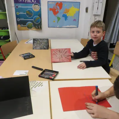 Un élève dessine à son bureau