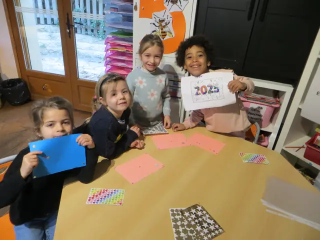 Des élèves souriants autour d’une table d’atelier