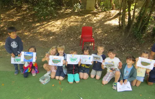 Les enfants montrent leurs dessins dans le jardin